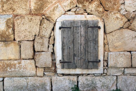 Closed window at the old Mediterranean stone house.