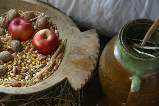 An apple and walnuts in an old wooden basket