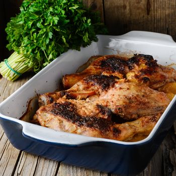 Baked chicken in a porcelain form on a rustic recipe