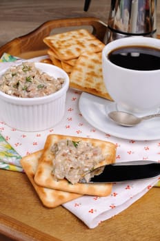 Appetizer of fish paste (forshmak) on a cracker with a cup of coffee