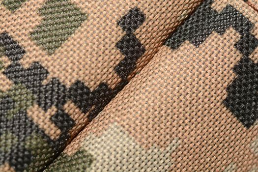 close up of worn out olive green tone camouflage fabric