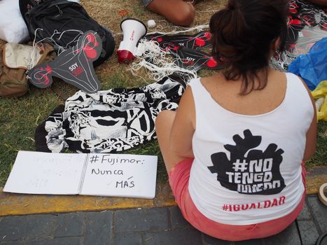 PERU, Lima: A protester sits next to a sign reading 'Fujimori, never again' as dozens of thousands of people took to the streets on April 5, 2016 in Lima against his daughter Keiko Fujimori who has a strong led in the polls, just five days before the presidential election in Peru. The right-wing candidate is currently in first place, with roughly 40 percent support ahead of the vote on April 10. But if she does not win at least 50 percent there will be a run-off in June.Protesters denouced the Fujimoru dictatorship.