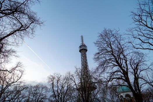 Bottom view of historical iron Petrin Tower, on bright blue sky background at sunset time.