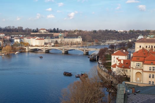 PRAGUE, CZECH REPUBLIC - DECEMBER 31, 2015 : Top view of Vltava river along Prague city with a bridge, from Old Town Bridge Tower on cloudy sky background.