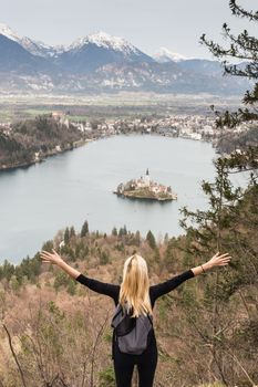 Made it. Young spoty active lady with hands rised admiring beautiful nature around Bled Lake in Julian Alps, Slovenia.
