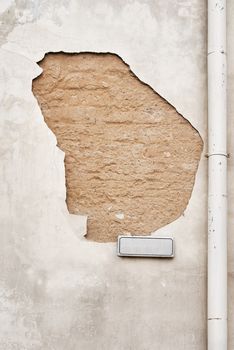cracked  wall with street sign and rain water pipe