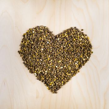 Heart shaped from raw dry brown lentils in cup, top view, square composition, food preparation, copy space, healthy lifestyle, eating legumes