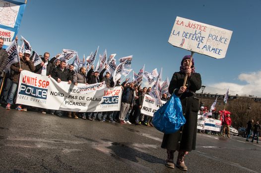 FRANCE, Paris : Police officers wave union flags as they take part in a protest called by the Unite-police SGP-FO police officers' union in Paris on April 7, 2016.A few thousand police officers, 8,000 according to organizers and 2,000 according to other police sources, demonstrated in Paris to demand the increase of a risk premium, in the wake of recent attacks and the state of emergency that is wearing out forces. 