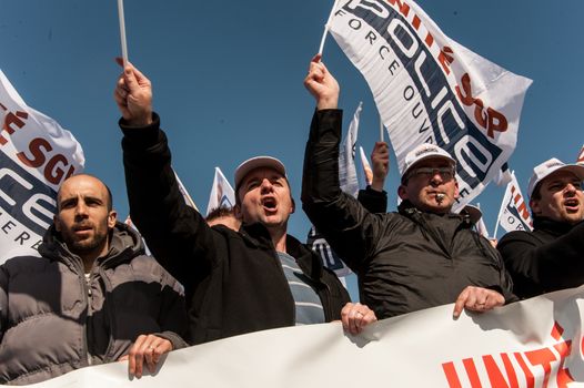 FRANCE, Paris : Police officers wave union flags as they take part in a protest called by the Unite-police SGP-FO police officers' union in Paris on April 7, 2016.A few thousand police officers, 8,000 according to organizers and 2,000 according to other police sources, demonstrated in Paris to demand the increase of a risk premium, in the wake of recent attacks and the state of emergency that is wearing out forces. 