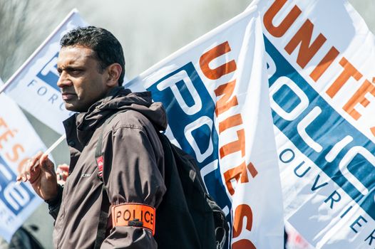 FRANCE, Paris : Police officers wave union flags as they take part in a protest called by the Unite-police SGP-FO police officers' union in Paris on April 7, 2016.A few thousand police officers, 8,000 according to organizers and 2,000 according to other police sources, demonstrated in Paris to demand the increase of a risk premium, in the wake of recent attacks and the state of emergency that is wearing out forces. 