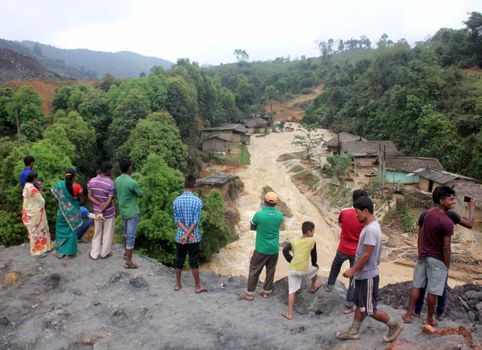 INDIA, Ledo: Indian people look at flooded village due to continuous heavy rains in Ledo, near Tinsukia, in the state of Assam, northeastern India, on April 7, 2016.