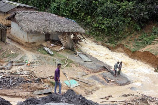 INDIA, Ledo: Men through flooded path due to continuous heavy rains in Ledo, near Tinsukia, in the state of Assam, northeastern India, on April 7, 2016.