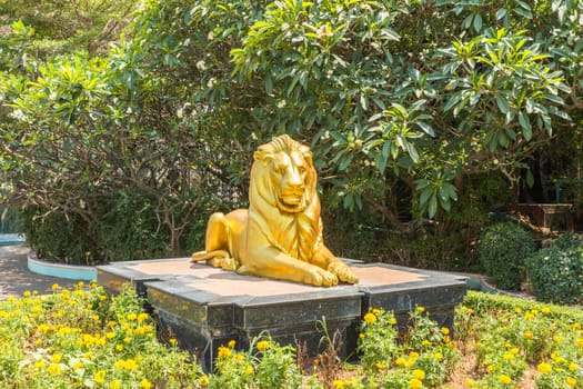 Sculpture of golden lion lying on a rock