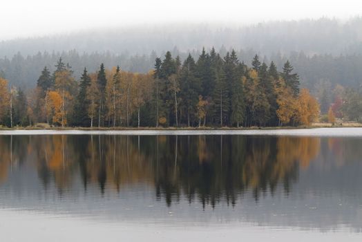 Autumn trees on the lakeshore - Kladska peats -Glatzener Moor -  is a national nature reserve in Slavkov Woods - protected landscape area. Slavkov Forest - Kaiserwald  is geomorphological unit in the northern part of the Carlsbad Highlands. Kladska, Czech republic.