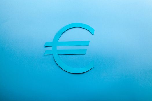 Blue euro symbol on a blue background with a soft light