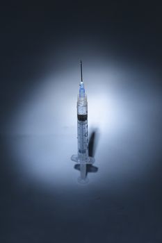 Long hypodermic needle ready for injection in a medical doctor’s office in the emergency room of a hospital.