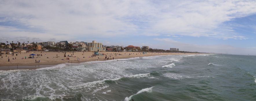 Along the Santa Monica coastline with a blue sky over the white sand of the beach in Southern California, United States.