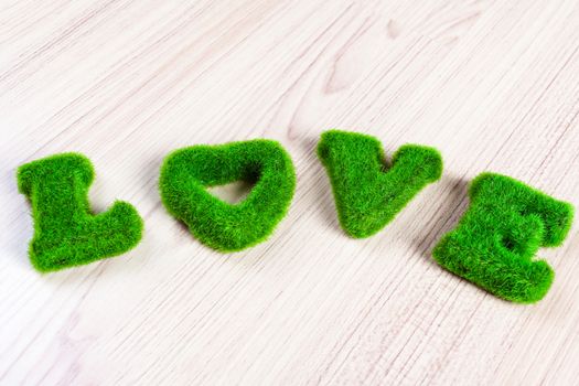 green love wording on wooden floor, made from artificial grass