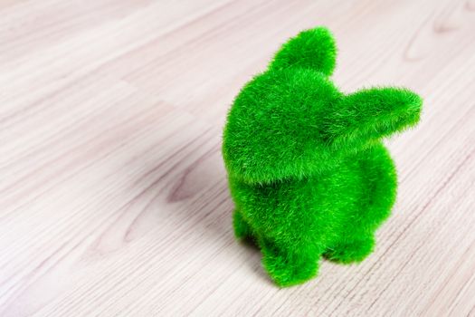 Little green rabbit on wooden floor, made from artificial grass