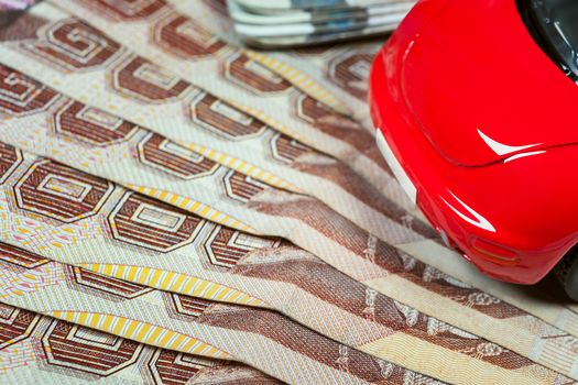 Thai baht banknotes and car mockup closeup on table background