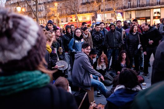 FRANCE, Paris: Militants of the Nuit debout (Standing night) movement play music as thousand gather on April 7, 2016 at the Place de la Republique in Paris, as participants plan to spend the night camped out to protest against the government's planned labour reform and against forced evictions. It has been one week that hundred of people have occupied the square to show, at first, their opposition to the labour reforms in the wake of the nationwide demonstration which took place on March 31, 2016.