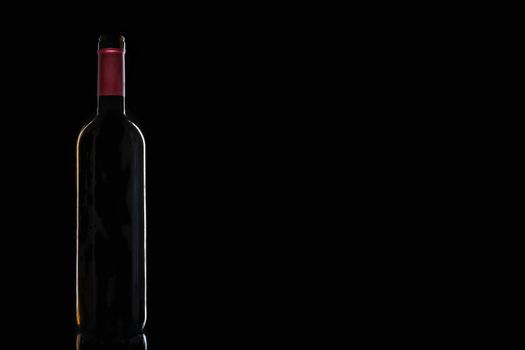 Bottle of red wine on black background