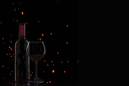 bottle of wine with a glass on a black background