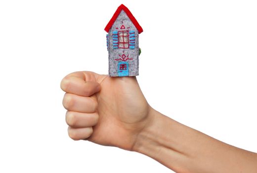 Toy house put on the thumb isolated on white background