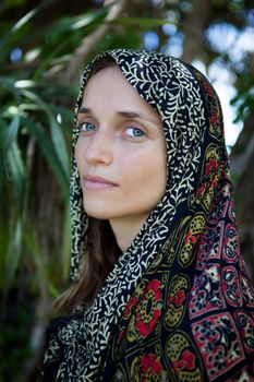 girl of European appearance in colored scarf on the background of nature
