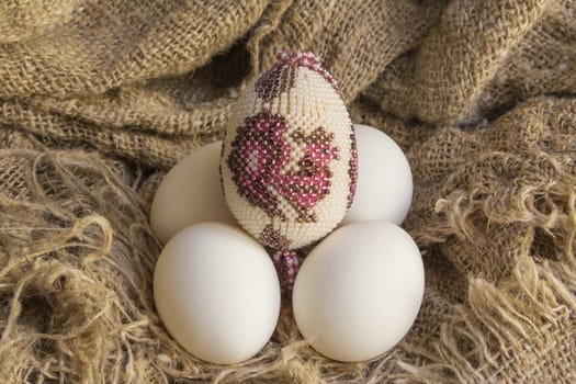 souvenir beaded egg on white raw eggs