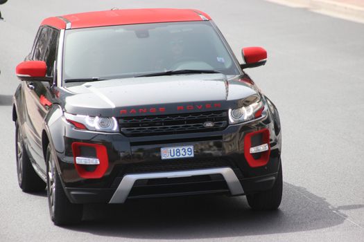 Monte-Carlo, Monaco - April 6, 2016: Land Rover Range Rover Evoque on Avenue d'Ostende in Monaco. Young Woman Driving a Red and Black Modern SUV in the south of France