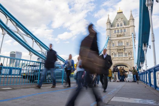 LONDON, UK – APRIL 05 2016: Motion blurred commuters crossing Tower Bridge during rush hour. Tower Bridge links the South of River Thames to the City area.