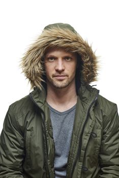 High key studio portrait of young adult caucasian model wearing winter coat with hood on staring into camera. Isolated on white.