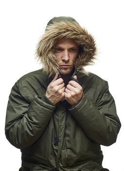 High key studio portrait of young adult caucasian model wearing winter coat with hood.