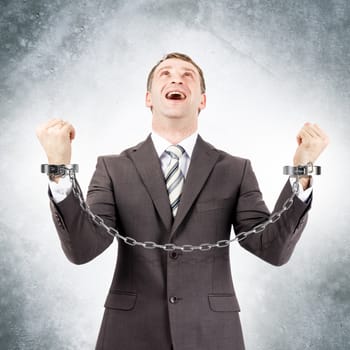 Happy businessman in cuffs on grey wall background