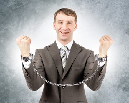 Happy businessman in cuffs looking at camera on grey wall background