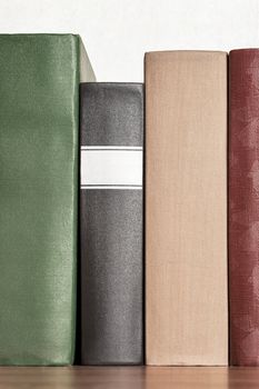 stack of books on the shelf, blank spines, close-up