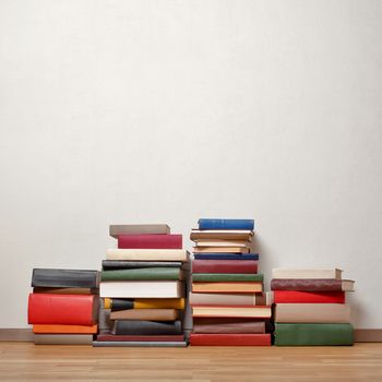 Severel stacks of old books on wooden floor