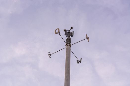 Weather station with anemometer on blue sky.