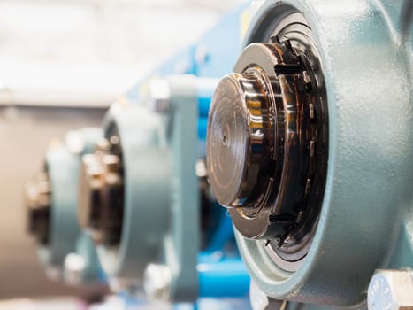 Ends of lubricated drive shafts exiting through ball bearings. Shallow depth of field with the nearest drive shaft in focus.