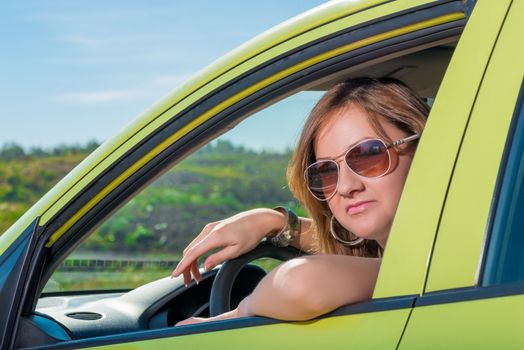 beautiful woman behind the wheel on a sunny day