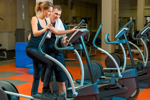 coach teaches an athlete in training in the gym