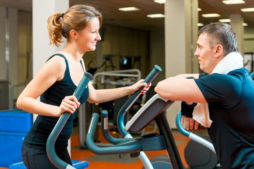 portrait of a girl in the gym and her trainer