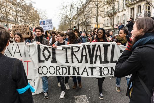 FRANCE, Paris: Demonstrators march behind a banner during a protest on April 9, 2016 in Paris, against the French government's proposed labour law reforms.