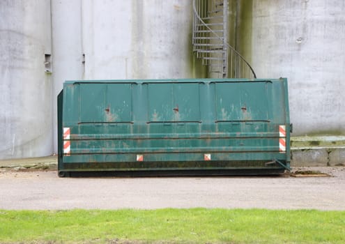 Green Worn Industrial Container with Concrete Wall Background and Staircase