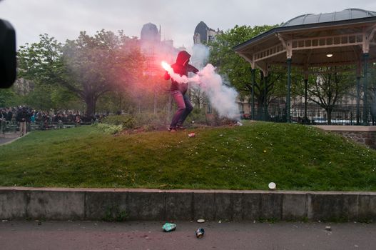 FRANCE, Paris: A protester holds a smokebomb during a demonstration against labour reform in Paris on April 9, 2016.