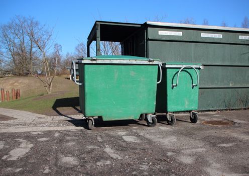 Two Green Garbage Containers on Asphalt Parking place