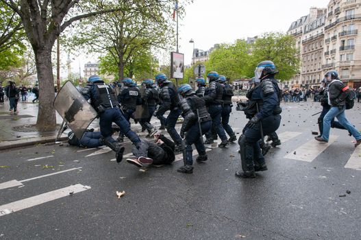 FRANCE, Paris: Riot policemen run over a protester during a demonstration against labour reform in Paris on April 9, 2016.