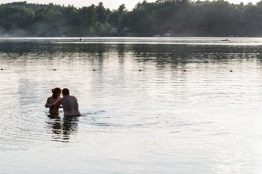 ChRYSTAL LAKE  - JULY 31: Young couple enjoy swimming in the lake on July 31, 2014 on Chrystal Lake in Maine, USA