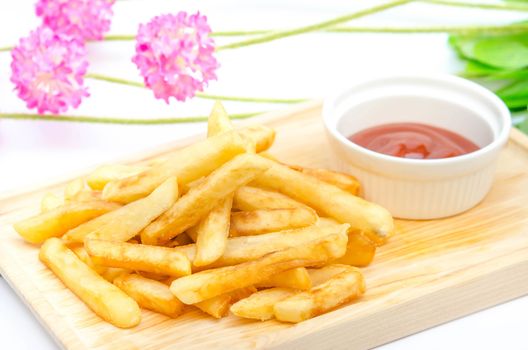 Traditional  French fries  on wooden plate with tomato sauce